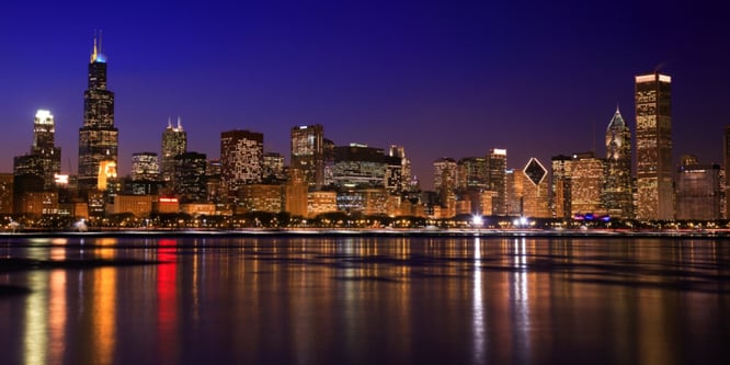 Chicago skyline reflecting off Lake Michigan at night.