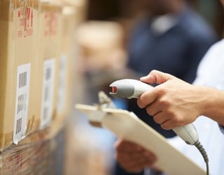 Scanning a barcode on a package to automatically take inventory for asset tracking supply chain.