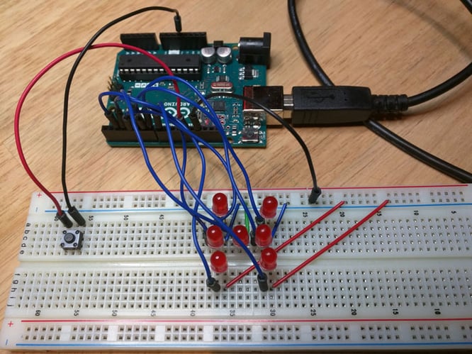 Arduino Uno module connected to a breadboard with seven LEDs.