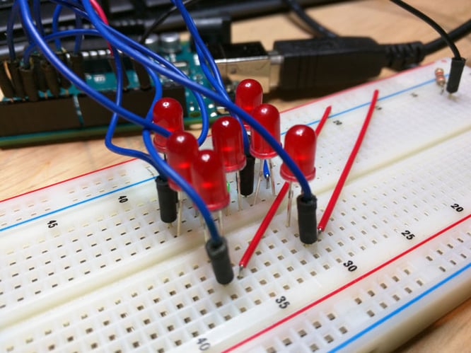 Seven LEDs on a breadboard with connections.