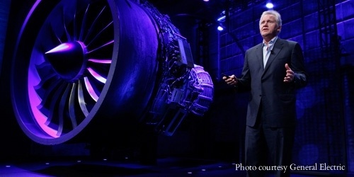 GE Minds+Machines event speaker presenting next to a giant aircraft engine.