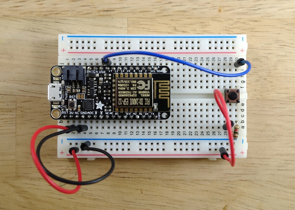 Adafruit Feather Huzzah hardware with a button attached to the board.