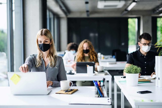Young-people-with-face-masks-back-at-work-office-after-lockdown-social-distance