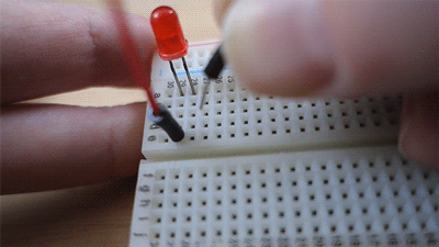Animation of LED on a breadboard lighting up with the use of terminals in the same row.