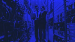 Two people conversing next to servers 
