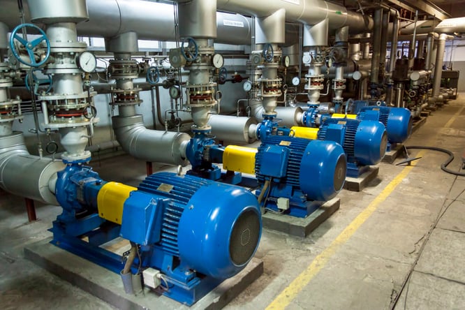 four blue and yellow industrial machines in a warehouse