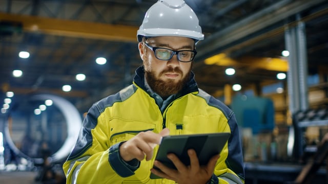 Manufacturing operations plant manager reviews IoT application data on iPad